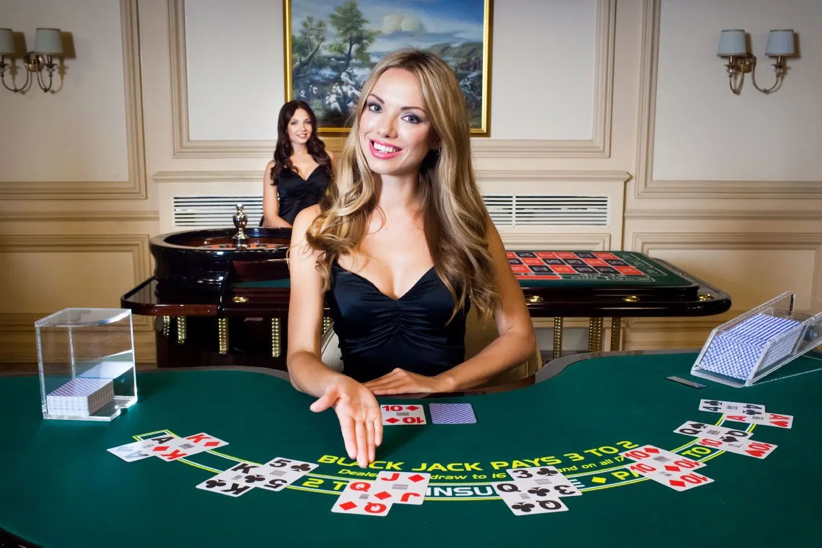 Dealer kasino live di depan meja permainan dan layar kamera